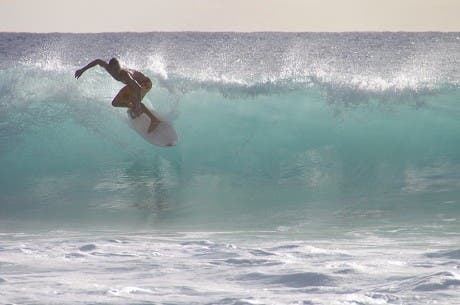 Fotografía de un surfista montando una ola