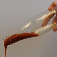 Imagen de ketchup fluyendo en una botella con LiquiGlide
