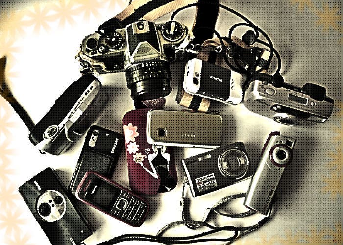 Varias cámara y móviles amontonados