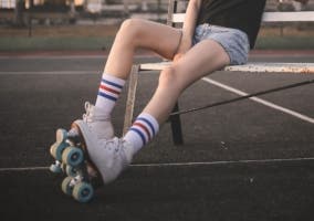 niña sentada con patines de cuatro ruedas