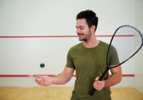 hombre con pelota y raqueta de squash