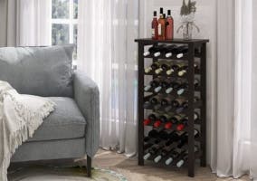 salón con un estante de botellas de vino y sillón gris