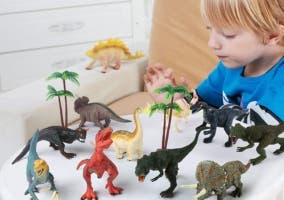 niño con dinosaurios de juguete